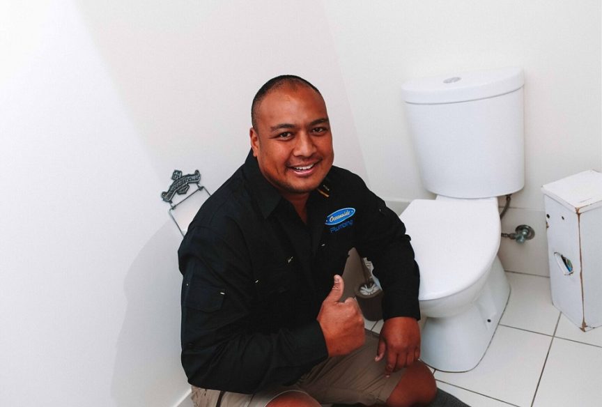 Smiling Employee next to the Toilet — Reliable Local Plumbers in Gold Coast
