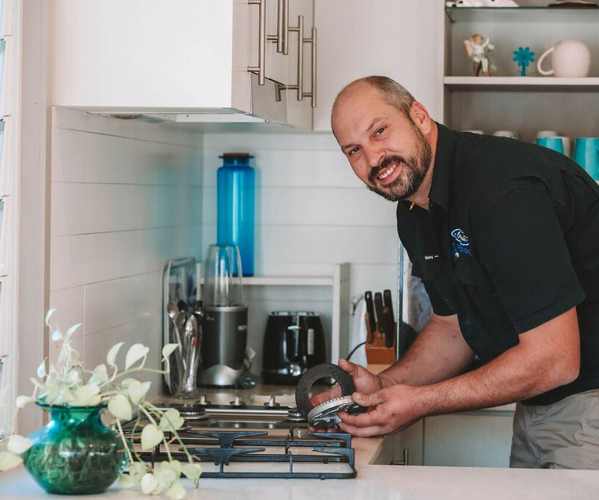Electrician Repairing Kitchen Stove — Reliable Local Plumbers in Gold Coast