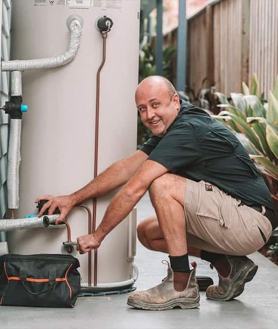 Plumber fixing hot water tank — Reliable Local Electricians in Helensvale, QLD