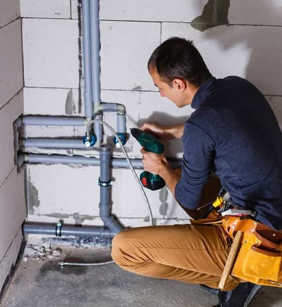 Plumber drilling hole — Reliable Local Electricians in Helensvale, QLD