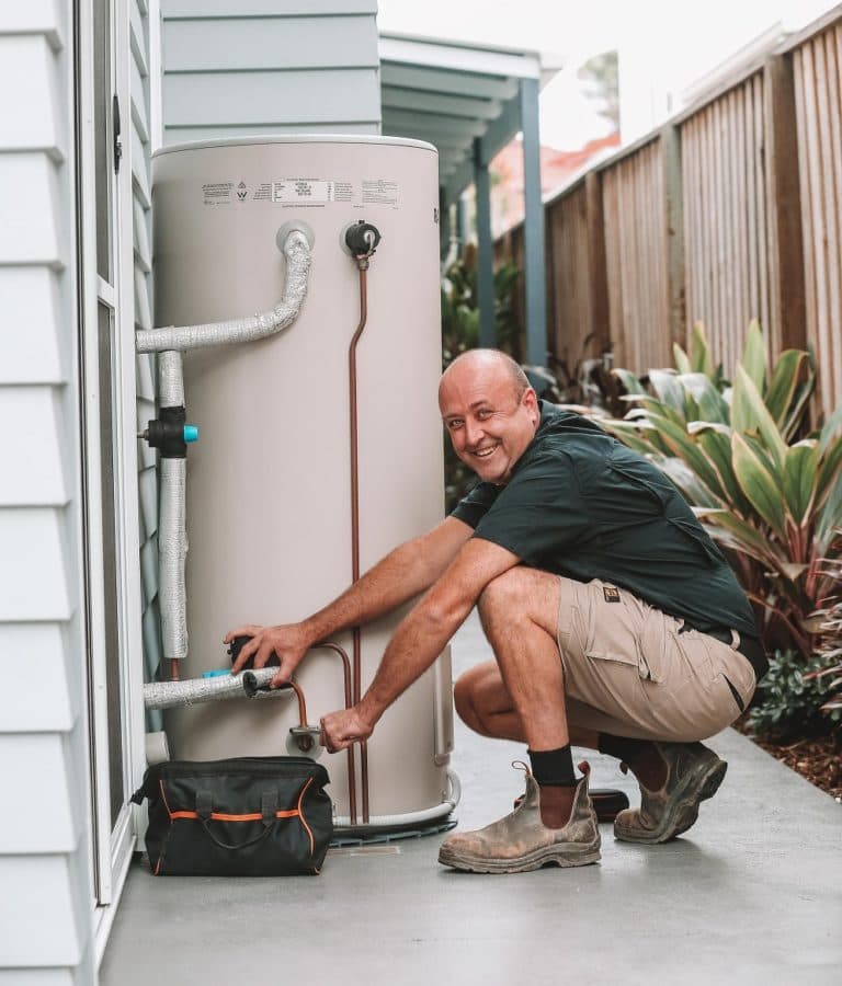 Plumber smiling while working — Reliable Local Electricians in Helensvale, QLD