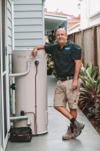 Plumber with hot water tank — Reliable Local Electricians in Helensvale, QLD