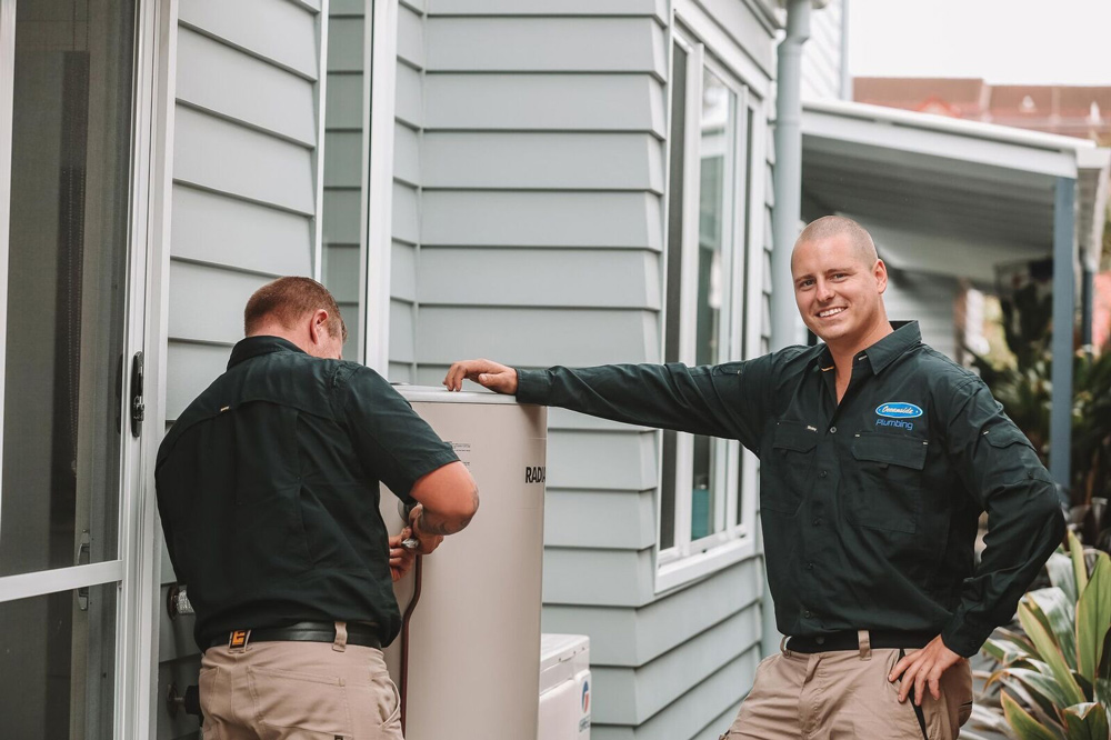 Two Professional Plumbers Inspecting Hot Water System