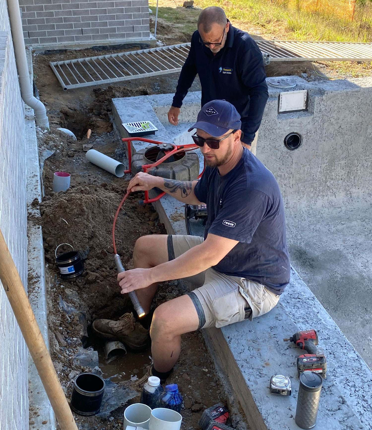 Plumber Inspecting A Pipe For Blocked Drainage