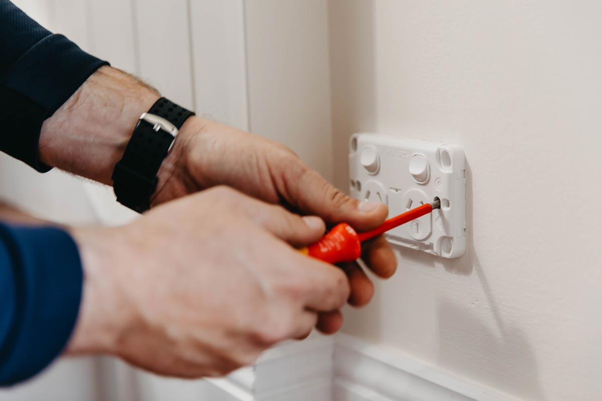 Closeup On An Electrician On The Gold Coast Installing Outlet